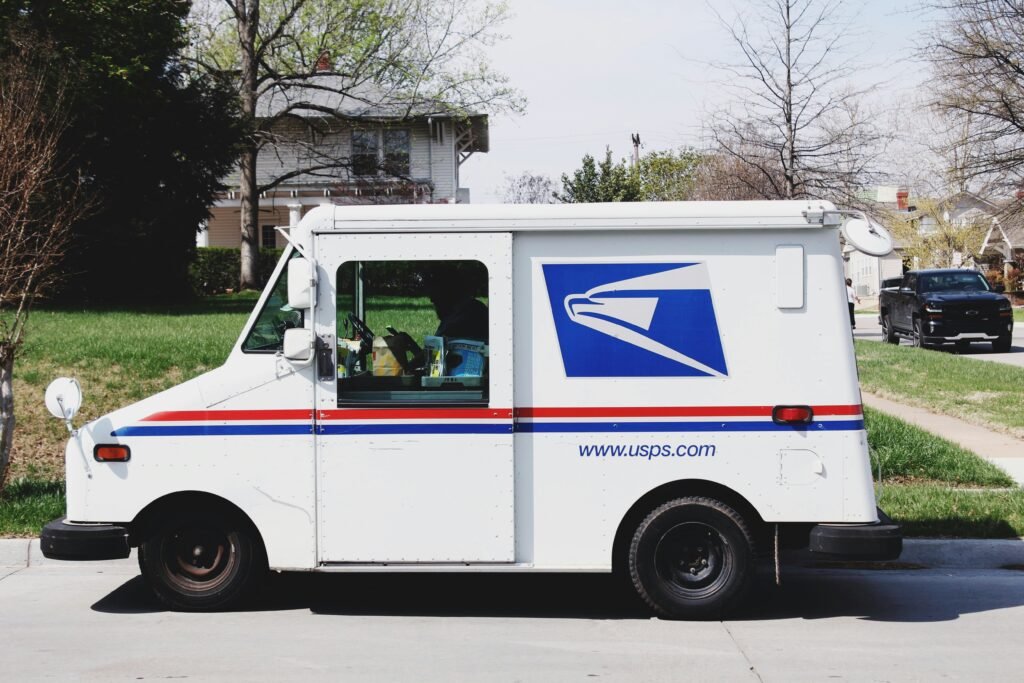 USPS mail delivery truck parked in a residential neighborhood during daytime.